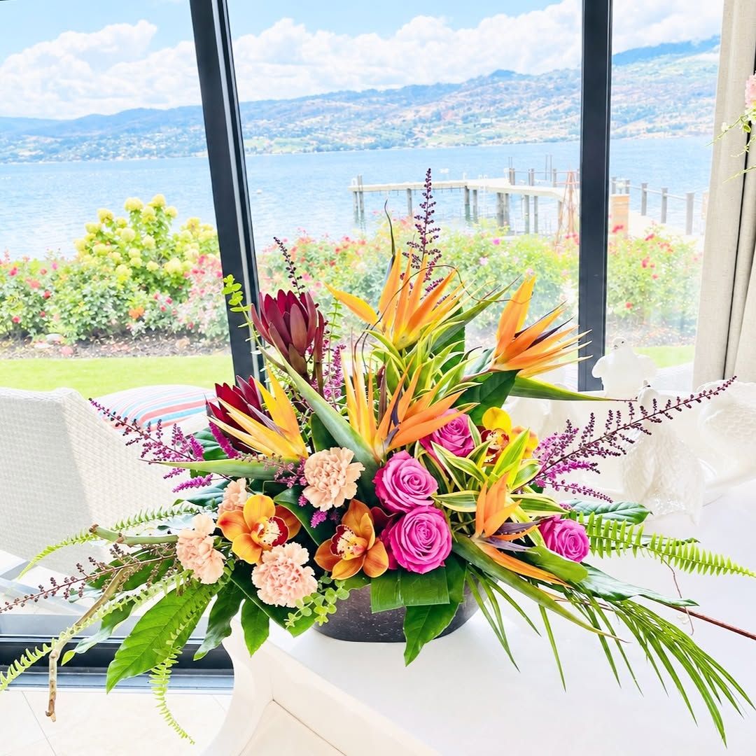 Tropical arrangement with bird of paradise by a lake-view window