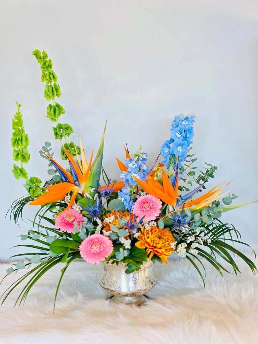 Blue delphinium and orange bird of paradise arrangement